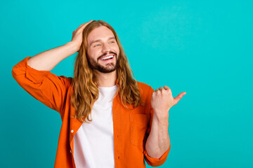 Photo portrait of smiling man in orange shirt promoter direct thumb copyspace desirable gta 6 trailer isolated on cyan color background