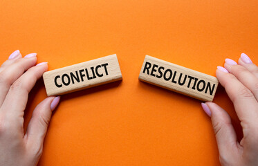 Conflict or Resolution symbol. Concept word Conflict or Resolution on wooden blocks. Businessman hand. Beautiful grey background. Business and Conflict or Resolution concept. Copy space