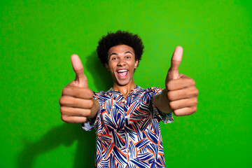 Portrait of overjoyed funny youngster positive man thumbs up indicate good feedback likes high...