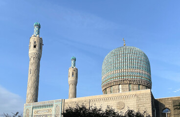 The dome of an Islamic mosque with the symbol of the hilal crescent moon in the blue sky