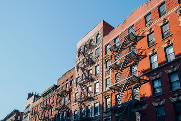 Row of typical New York apartment blocks with fire escape in Nolita,New York City, USA. - obrazy, fototapety, plakaty