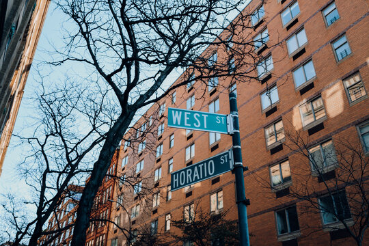 Street name signs on the corner of West and Horatio streets in New York City, USA.