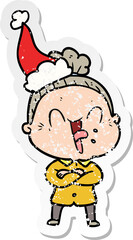 distressed sticker cartoon of a happy old woman wearing santa hat