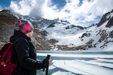 Mujer senderista disfrutando las vistas de la Laguna de los Tres, debajo del cerro Fitz Roy. Sendero de El Chalten, Patagonia Argentina - obrazy, fototapety, plakaty