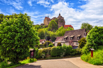 Fototapeta na wymiar Anblick der Burg Hohenstein mit alten Fachwerkhäusern in Mittelfranken, Bayern, Deutschland vor weiß-blauem Himmel