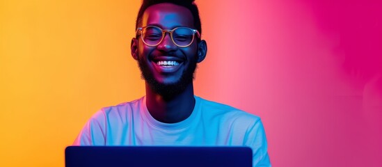 Blue Perennial colored man with a laptop and glasses, smiling in trendy neon light for cyber security and technology, showcasing open laptop copy space for a big date as a freelancer.