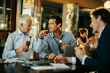 Group of business people having an after work beer in a cafe or bar