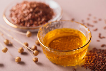 Brown linen seeds, flaxseed vegetable oil on beige background