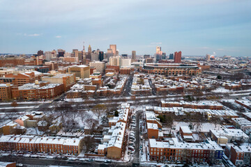 Drone View of Baltimore City Skyline with Snow Covered Roofs at Sunset with Blue Skies
