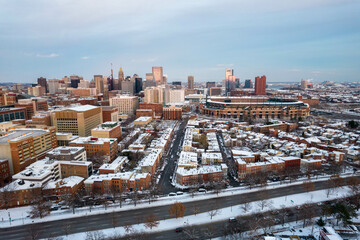 Drone View of Baltimore City Skyline with Snow Covered Roofs at Sunset with Blue Skies