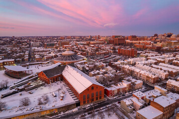 Drone View of Baltimore City Houses with Snow Covered Roofs at Sunset with Orange and Pink Skies