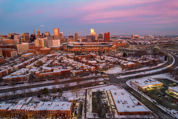 Drone View of Baltimore City Skyline with Snow Covered Roofs at Sunset with Pink Skies
