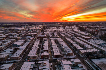 Drone View of Baltimore City Houses with Snow Covered Roofs at Sunset with Orange and Pink Skies