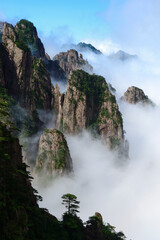 Misty clouds hover around Cloud Dispersing Pavillion's Boot Rock in the Yellow Mountains of China.