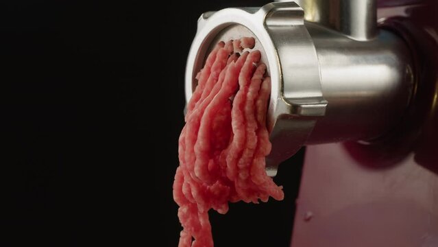 Twist a meat or pork fart in a meat grinder close-up macro. Mince chicken comes out of the meat grinder at home. Cooking stocks of minced meat at home