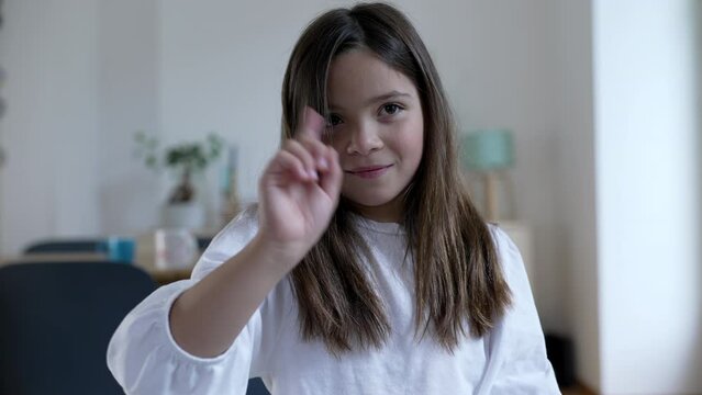 Child waves finger to camera saying NO, one little 8 year old girl in REJECTION