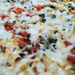 cooking delicious pizza with sausage, tomatoes and cheese at home close-up. ingredients for baking cheese, sausage, tomato sauce and tomatoes, corn, olives. delicious snack for children and adults