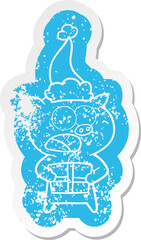 cartoon distressed sticker of a pig with christmas present wearing santa hat