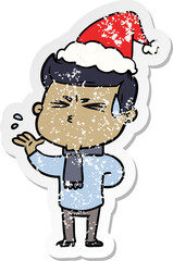 distressed sticker cartoon of a man sweating wearing santa hat