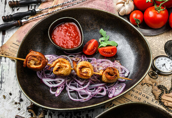 Grilled meat chicken shish on skewers with vegetables and tomato sauce on the plate. Healthy food. Hot meat dishes, kebab food, closeup, selective focus