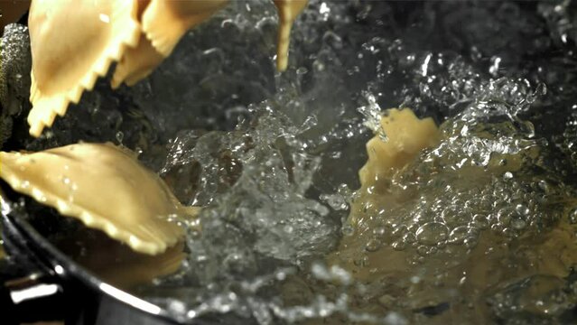 Italian ravioli falls into a pot of water. Filmed on a high-speed camera at 1000 fps. High quality FullHD footage