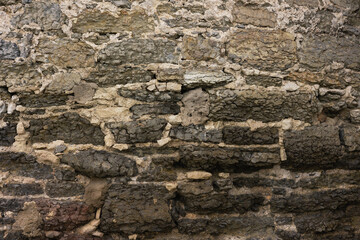 Texture of an ancient weathered stone wall