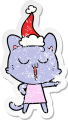 distressed sticker cartoon of a cat singing wearing santa hat