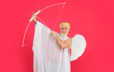 Valentines day. Love and romance. Smiling male angel aiming with bow and arrow. Valentine cupid in...