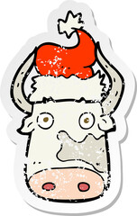 retro distressed sticker of a cartoon cow wearing christmas hat