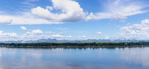 Panorama view of Laos along Mekong river, Big mountain, small villages and forest, Riverside between Thai and Laos border with blue sky, Nakhon Phanom province, Northeastern Thailand also called Isan.