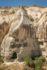 Typical stone dwelling carved in the fairy chimneys with dovecotes carved in the volcanic rock,...