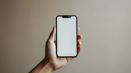 Fototapeta na wymiar Hand holding isolated smartphone device mockup with blank empty white screen on home office studio background wallpaper, communication technology concept