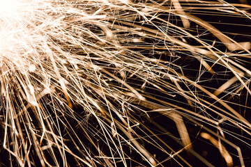 Sparks isolated on black. New years eve sparkler background. Industrial factory machine sparks. Cutting metal danger. Glowing effect texture. Motion of flying sparks. Fire background. 