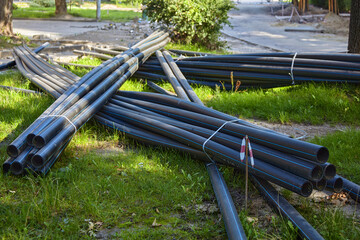 a bunch of black plastic pipes on the green grass lawn
