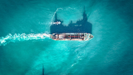 Aerial view of cargo ship in blue waters by Newhaven port, East Sussex, UK