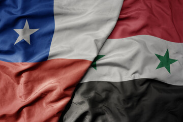 big waving national colorful flag of syria and national flag of chile .