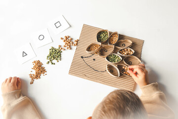 Montessori and Sensory Development, A child plays with natural materials and sorts cereals