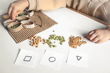 Montessori and Sensory Development, A child plays with natural materials and sorts cereals