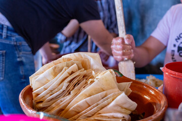 corn husks skillfully arranged to wrap Mexican tamales. concept creativity and passion in traditional cooking.