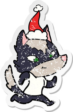 friendly distressed sticker cartoon of a wolf wearing santa hat