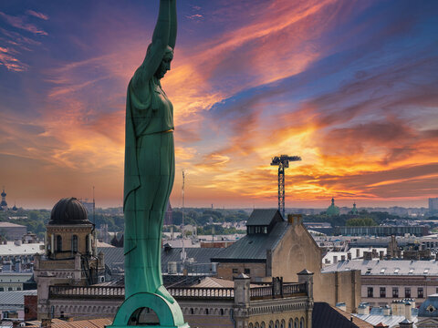 Beautiful sunrise view over Riga by the statue of liberty - Milda in Latvia. The monument of freedom.