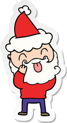 man with beard sticking out tongue wearing santa hat