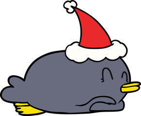 penguin lying on belly wearing santa hat