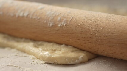 Rolling Pin Flattening Dough. Close-up, shallow dof.
