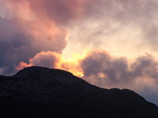 Dramatic cloud formation over mountain ridge during sunset 