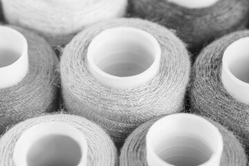 Fototapeta na wymiar Plastic spools of thread for a sewing machine, black and white.