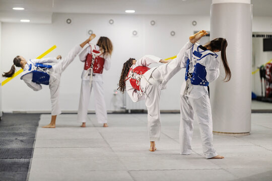 Taekwondo girls in combat wearing doboks in martial art school.