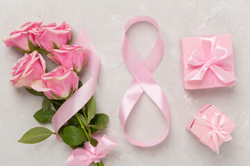Composition with pink roses, gift box and eight made of ribbon on concrete background, top view. Women's day concept