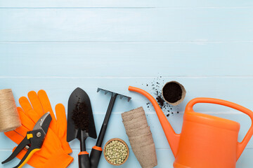 Orange gardening tools on wooden background, top view