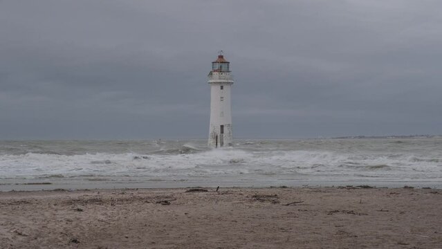 New Brighton Lighthouse on stormy day with waves crashing onto it